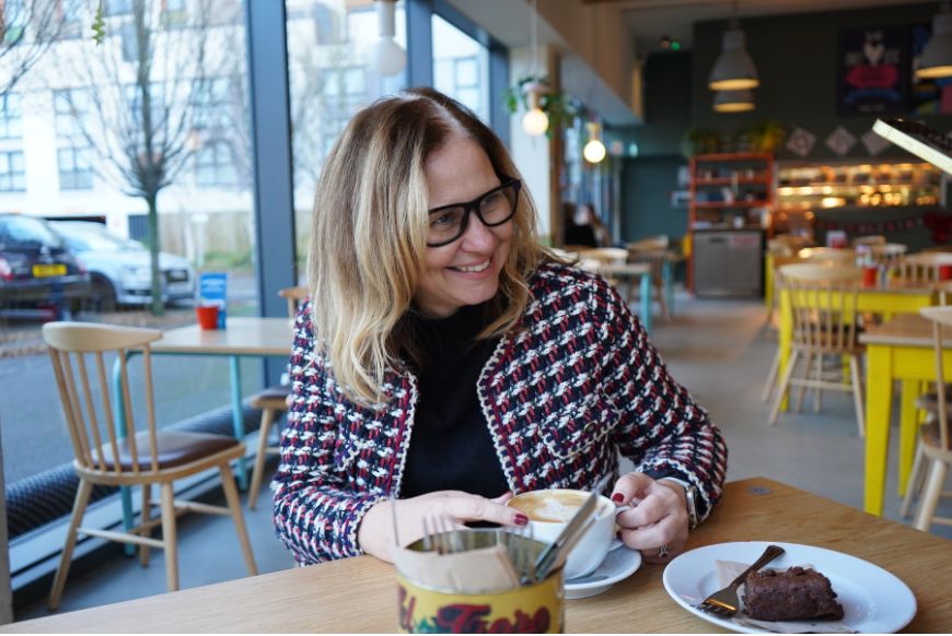 woman holding a mug of coffee at a cafe